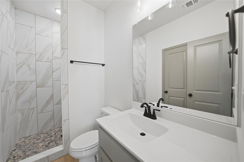 103 South Barron Street Covington, TX 76636 - Photo 13 of 16 a bathroom with a sink a toilet and shower