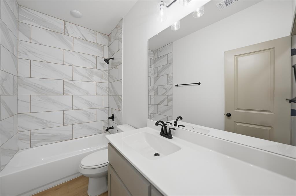 103 South Barron Street Covington, TX 76636 - Photo 9 of 16 a bathroom with a sink a toilet and shower