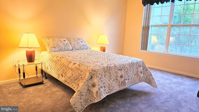 a bed sitting in a bedroom next to a window