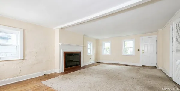 an empty room with windows fireplace and windows