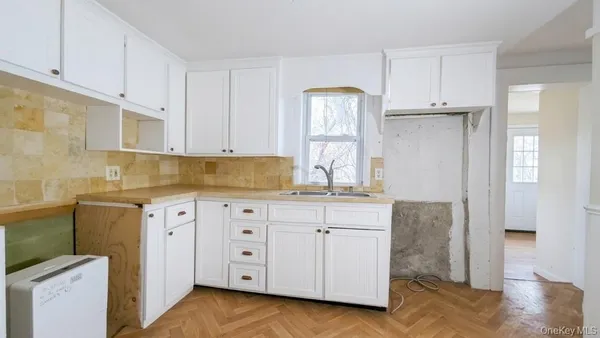 a kitchen with granite countertop white cabinets and sink