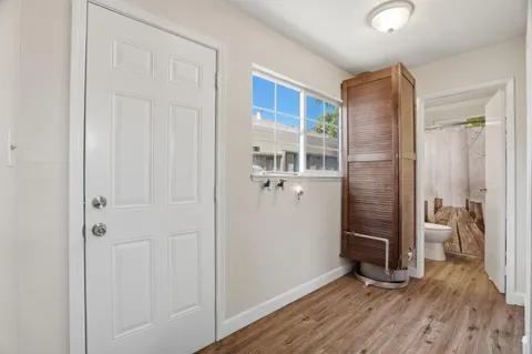 a view of a hallway with wooden floor and closet area