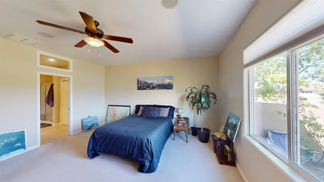 a spacious bedroom with a bed and a large window