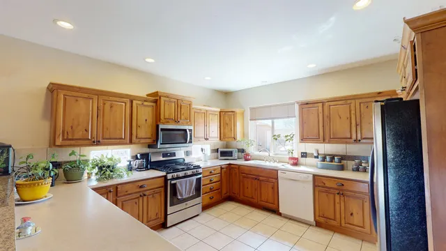 a kitchen with granite countertop a stove top oven a sink a counter space and cabinets