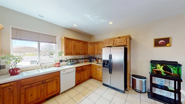 a kitchen with stainless steel appliances granite countertop a refrigerator a sink a stove and wooden cabinets