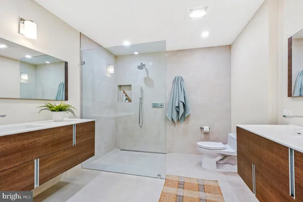 a spacious bathroom with a double vanity sink toilet and shower