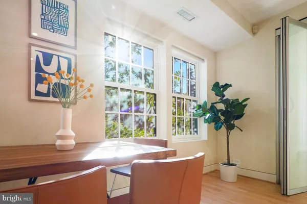 a vase of flowers sitting on a table with a bookshelf