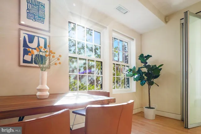 a vase of flowers sitting on a table with a bookshelf