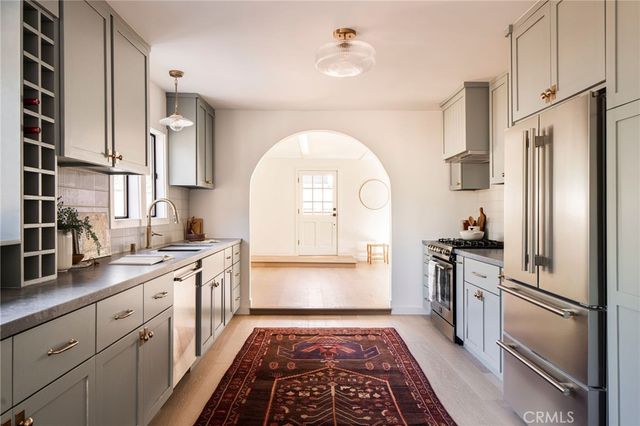 a large kitchen with stainless steel appliances granite countertop a refrigerator sink and stove