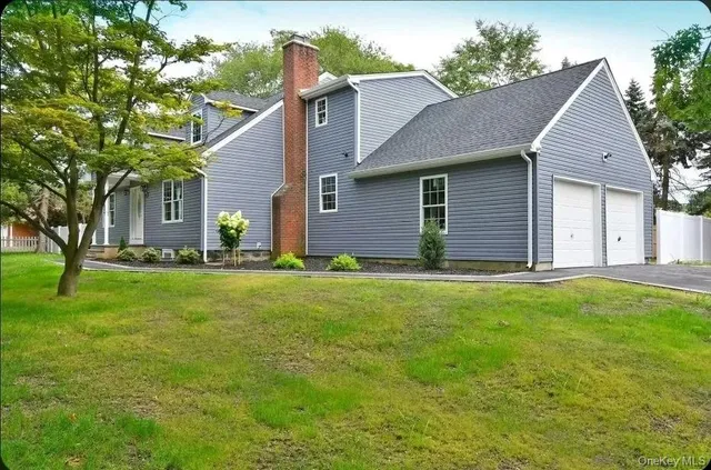 a front view of a house with a yard and trees