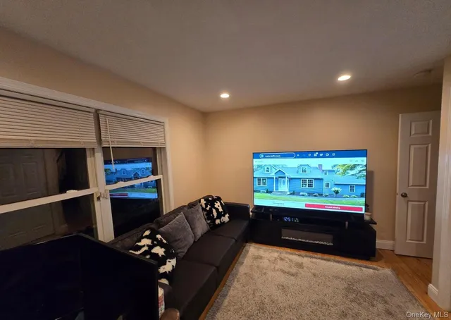 a living room with furniture pool table and a flat screen tv