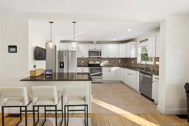 a living room with furniture a table and kitchen view