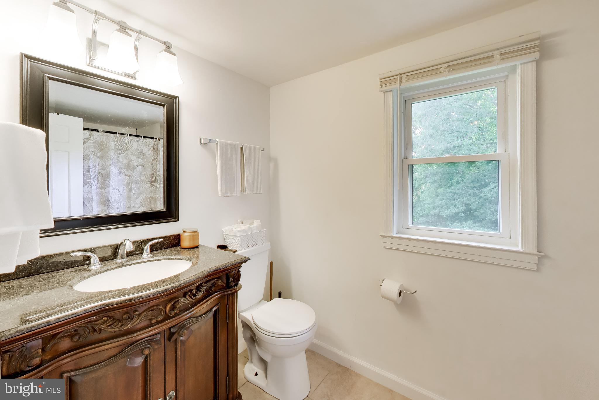 3240 Juniper Lane Huntingtown, MD 20639 - Photo 17 of 48 a bathroom with a granite countertop toilet sink and mirror