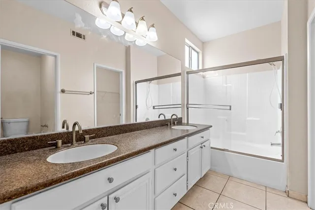 a bathroom with a granite countertop double sink and a mirror