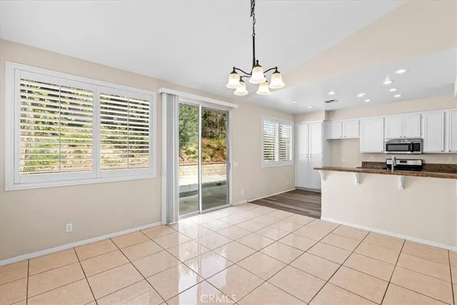 a view of kitchen with stainless steel appliances kitchen island granite countertop a refrigerator and a stove top oven