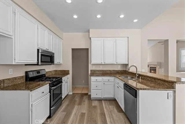 a kitchen with granite countertop white cabinets and white appliances