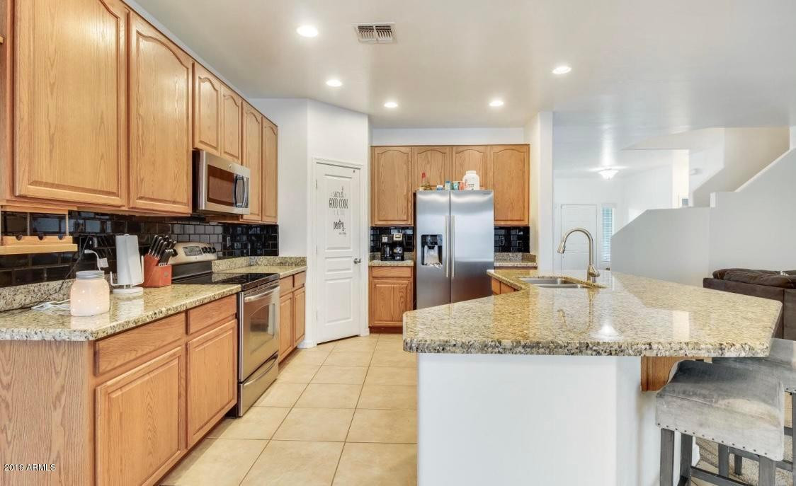 16741 West Tether Trail Surprise, AZ 85387 - Photo 2 of 20 a large kitchen with granite countertop a large counter top stainless steel appliances and cabinets