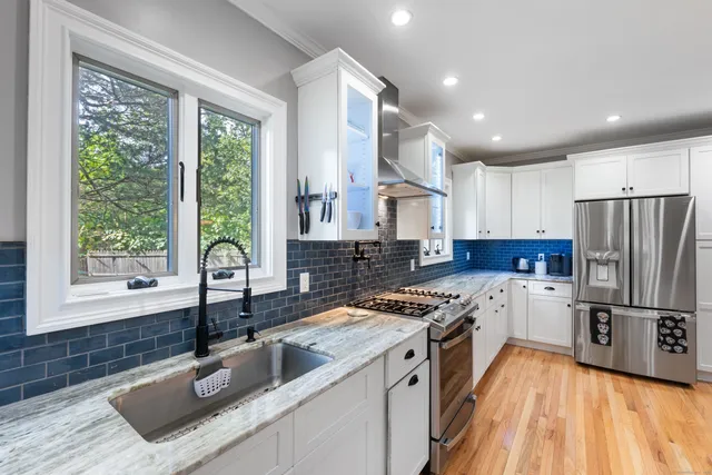 a kitchen that has a sink stainless steel appliances a window and a counter top space