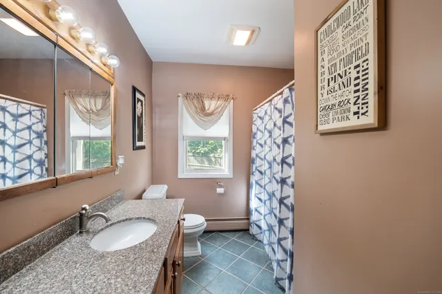 a bathroom with a sink a toilet and a shower curtain