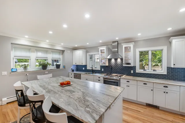 a large kitchen with kitchen island a stove a table and chairs