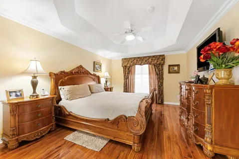 a bedroom with a bed and wooden floor