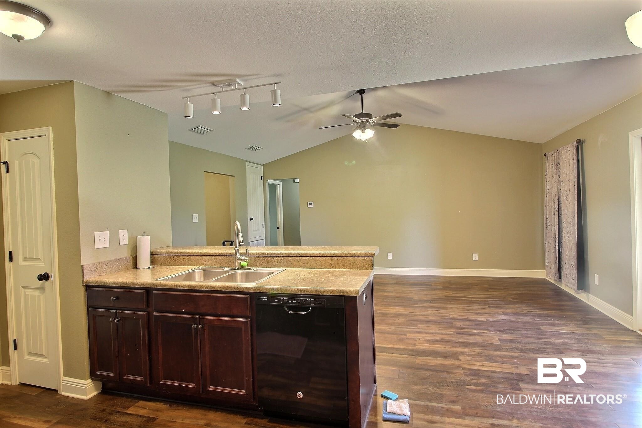 15577 Talus Court Foley, AL 36535 - Photo 27 of 28 Kitchen featuring a peninsula, black dishwasher, open floor plan, dark brown cabinets, and lofted ceiling
