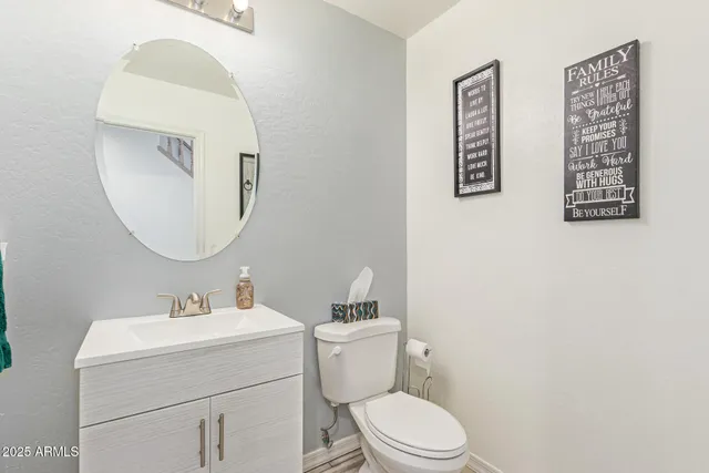 a bathroom with a granite countertop sink a toilet a mirror and shower