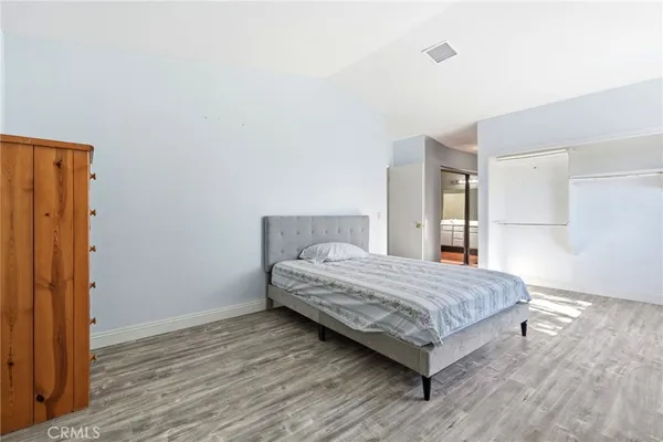 a bedroom with a bed and wooden floor