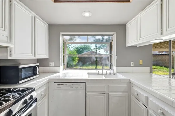 a kitchen with granite countertop a sink stainless steel appliances and cabinets