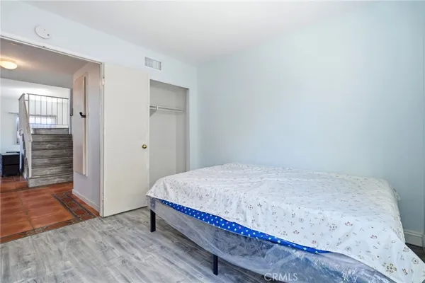 a bedroom with a bed and wooden floor