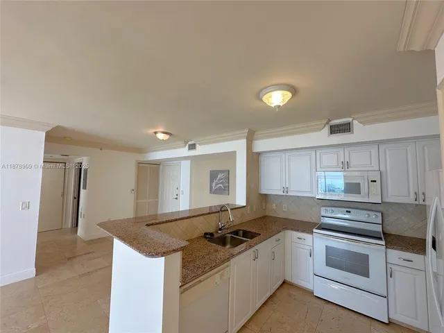 a kitchen with granite countertop a stove top oven sink and cabinets