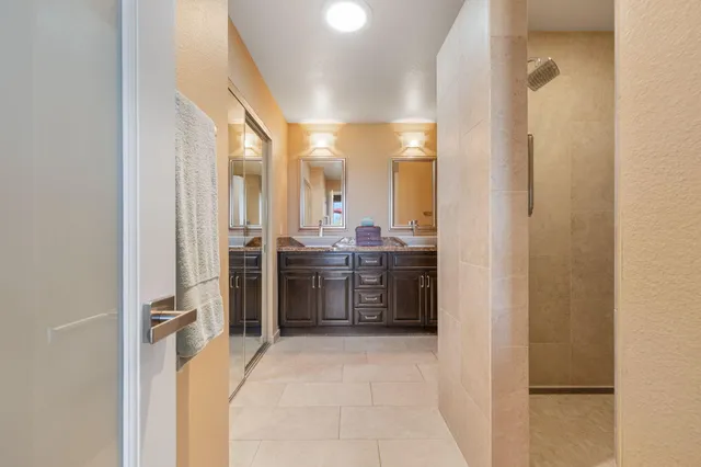a bathroom with a double vanity sink mirror double and shower