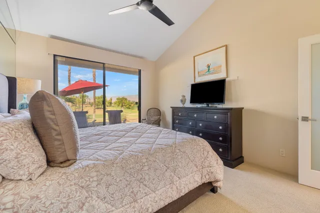 a bed room with a bed tv and a chair