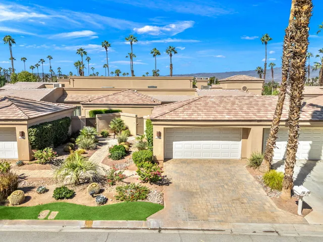 an aerial view of a house with a yard and a large tree