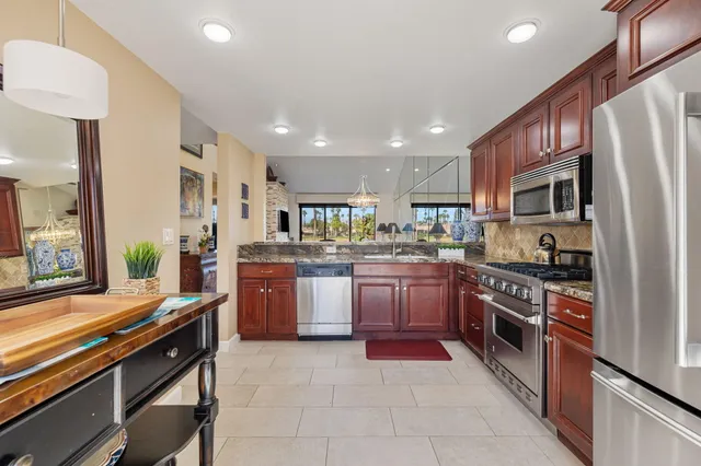 a kitchen with stainless steel appliances granite countertop a refrigerator sink and stove