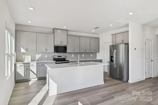 a kitchen with stainless steel appliances a refrigerator stove microwave and sink