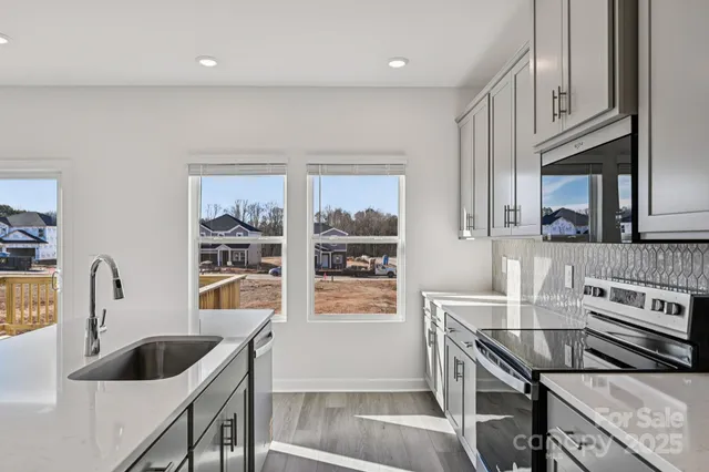 a kitchen with stainless steel appliances granite countertop a sink and a stove
