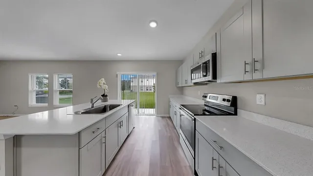 a kitchen with white cabinets and stainless steel appliances