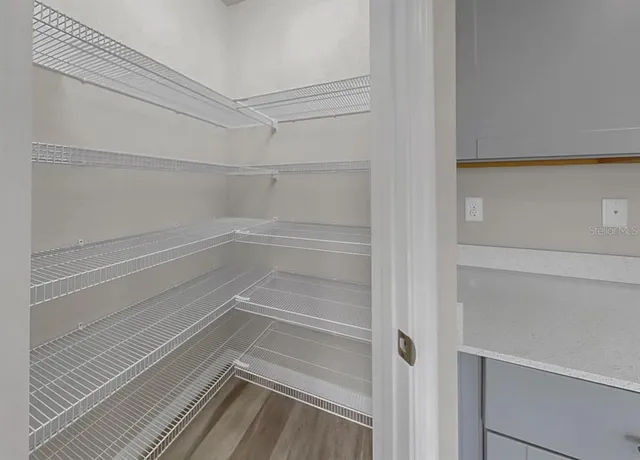 a spacious bathroom with a double vanity sink a toilet and a mirror