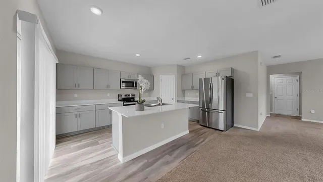 a kitchen with a sink stainless steel appliances and white cabinets