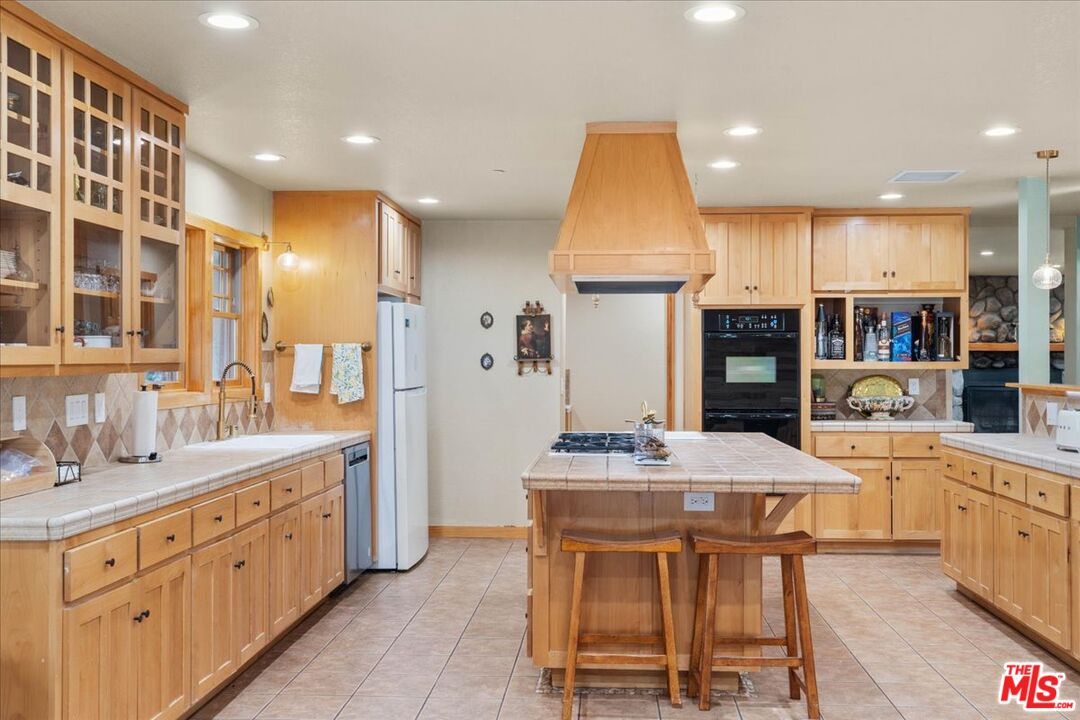28200 Pine Canyon Road Lake Hughes, CA 93532 - Photo 14 of 52 a kitchen with stainless steel appliances kitchen island granite countertop a sink and cabinets