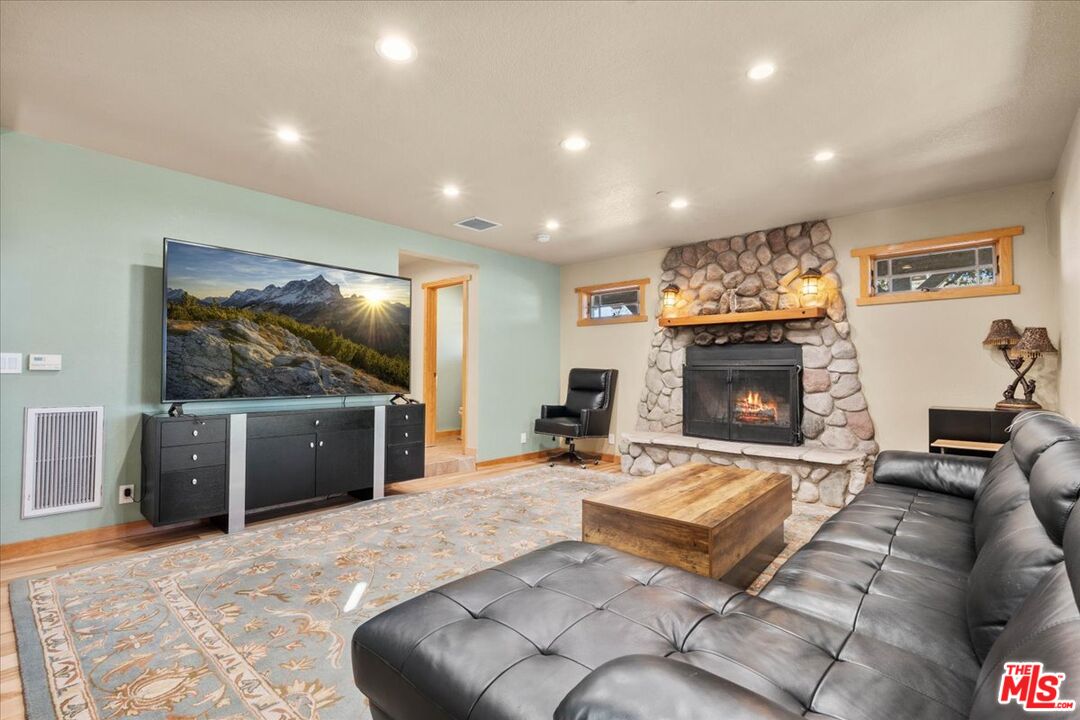 28200 Pine Canyon Road Lake Hughes, CA 93532 - Photo 17 of 52 a living room with furniture a flat screen tv and a fireplace