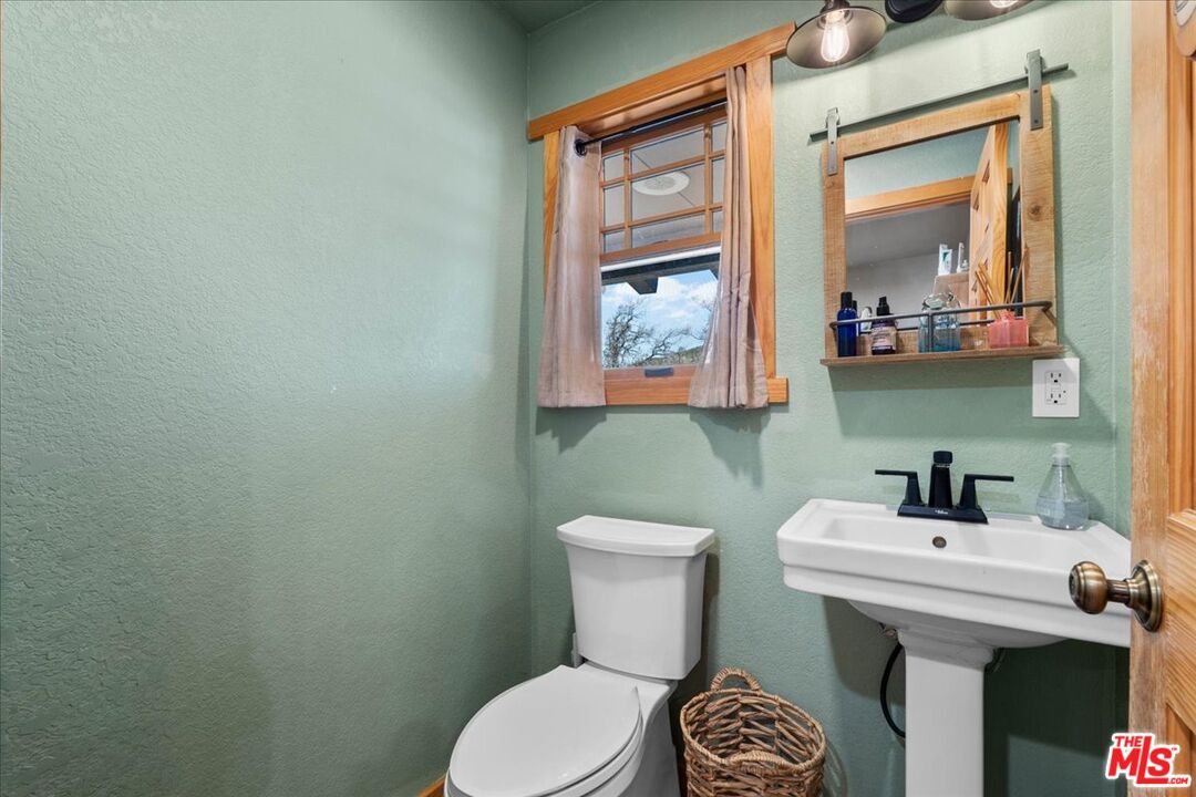 28200 Pine Canyon Road Lake Hughes, CA 93532 - Photo 20 of 52 a bathroom with a toilet a sink and mirror