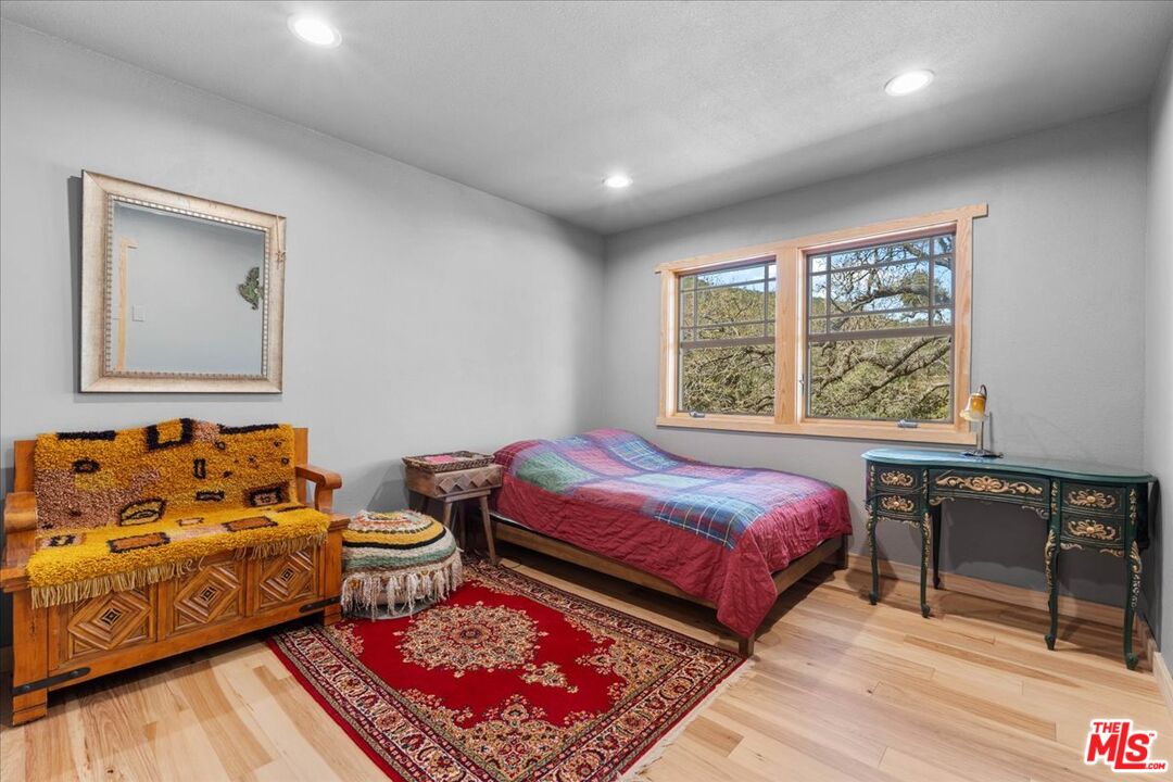 28200 Pine Canyon Road Lake Hughes, CA 93532 - Photo 22 of 52 a bedroom with a bed and wooden floor