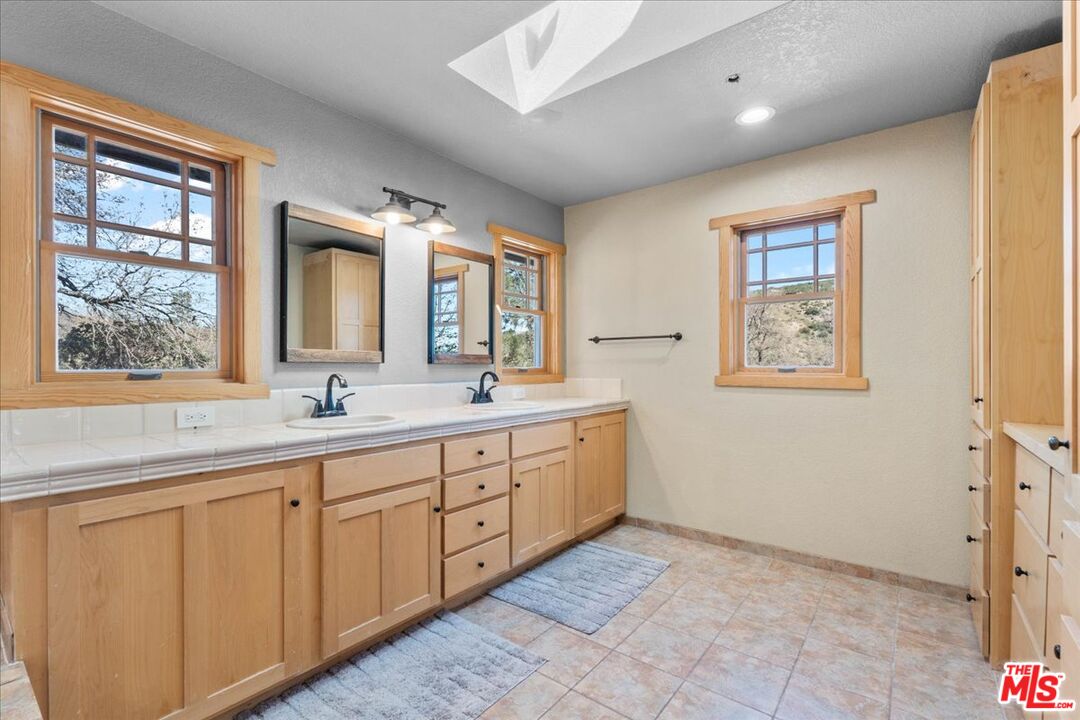 28200 Pine Canyon Road Lake Hughes, CA 93532 - Photo 33 of 52 a spacious bathroom with a double vanity sink and a mirror