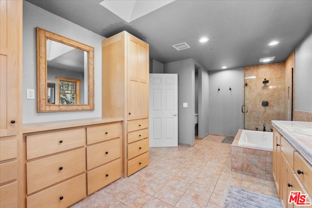 28200 Pine Canyon Road Lake Hughes, CA 93532 - Photo 34 of 52 a spacious bathroom with a shower sink and mirror