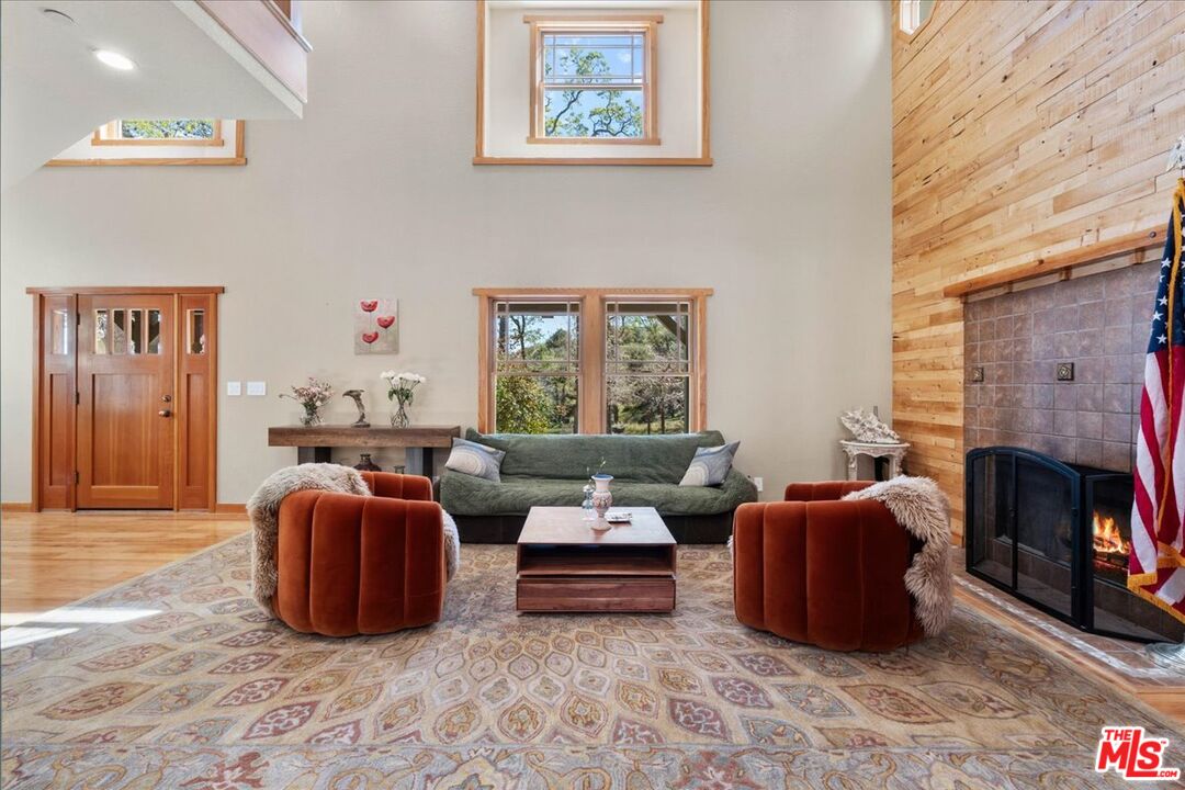 28200 Pine Canyon Road Lake Hughes, CA 93532 - Photo 6 of 52 a living room with furniture a fireplace and a large window