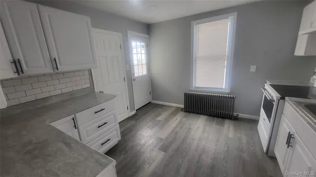 a view of kitchen and hallway with wooden floor