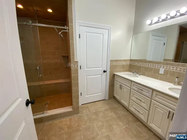a bathroom with a shower sink and mirror