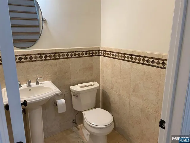 a bathroom with a toilet a sink and mirror